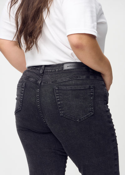 Mørkegrå denim slim jeans set bagfra tæt på en plus-size model for at vise detaljer.