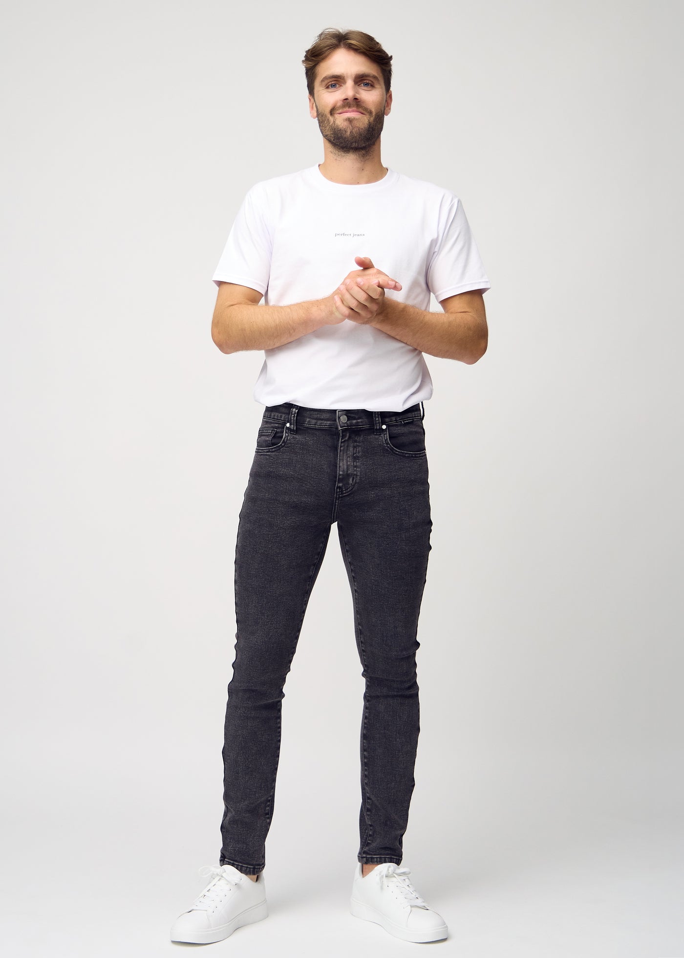 Fuldt billede af model i mørkegrå denim slim jeans.