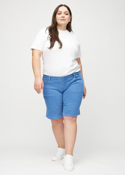 Plus-size model går ind i billedet, strækker i sine shorts, viser dem frem ved at dreje rundt, og forlader derefter billedet.